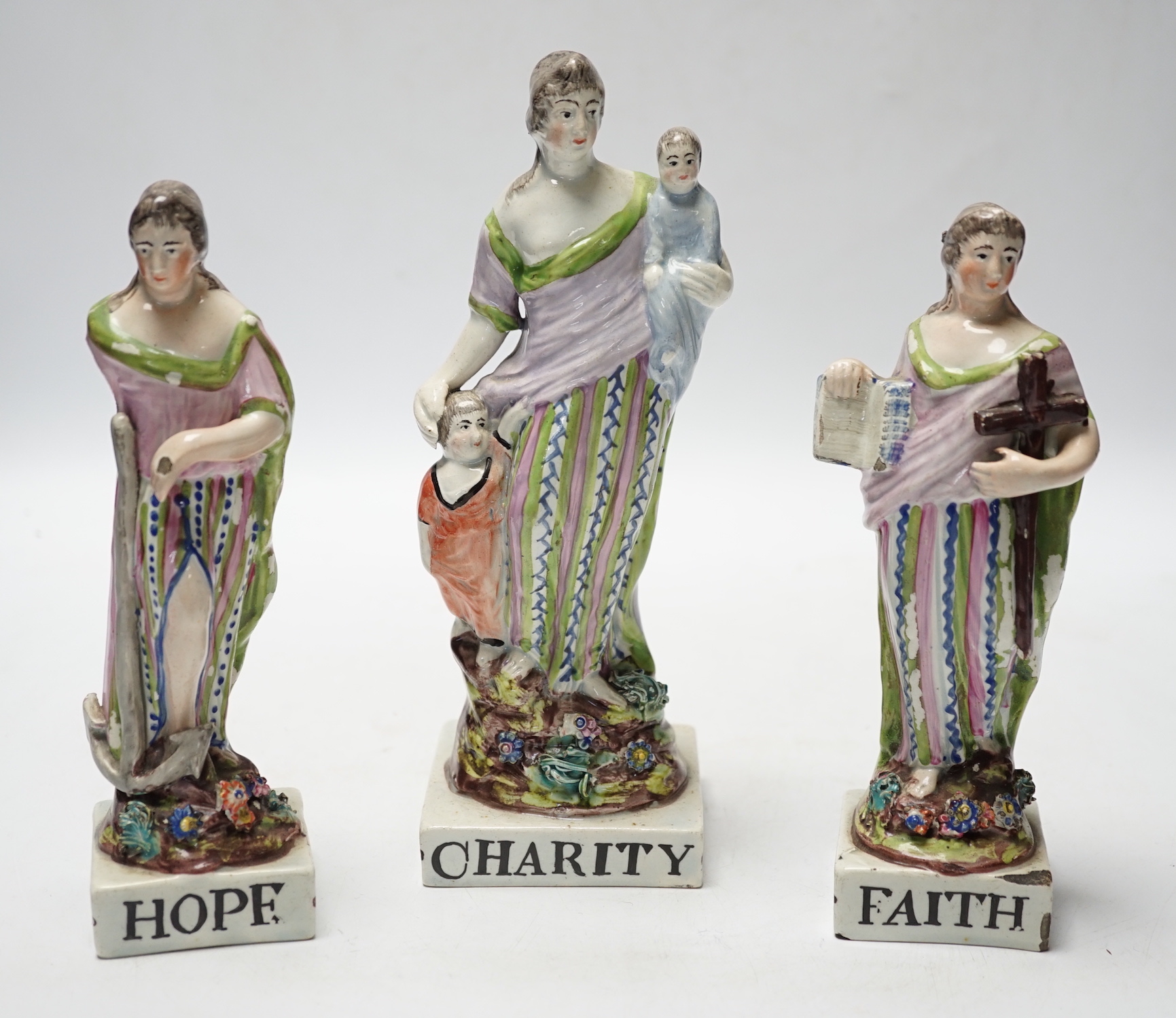 A set of three pearlware figures of Faith, Hope and Charity, c.1810, largest 21cm high